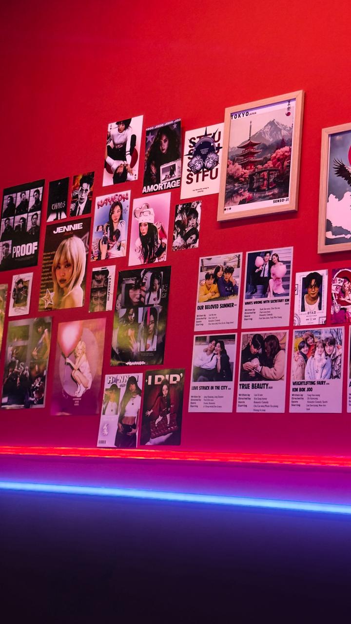 Wall covered in K-pop and K-drama posters with blue neon strip lighting